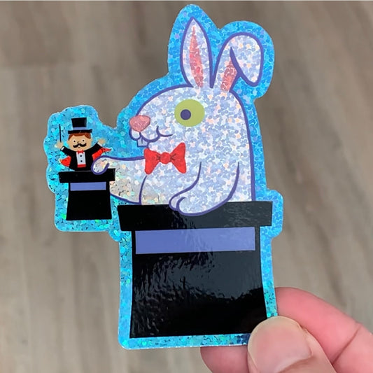 a rabbit pulling a tiny magician out of a top hat sticker with glitter effect